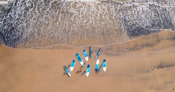 group of people paddleboarding stood on the beach at Seaham.
